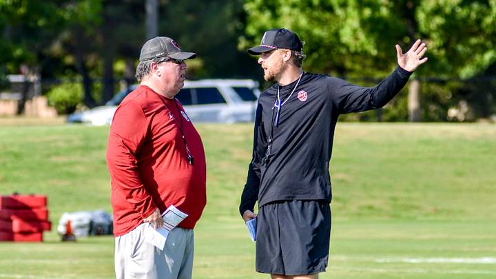 Oklahoma offensive line coach Bill Bedenbaugh talks to offensive coordinator Ben Arbuckle during practice.