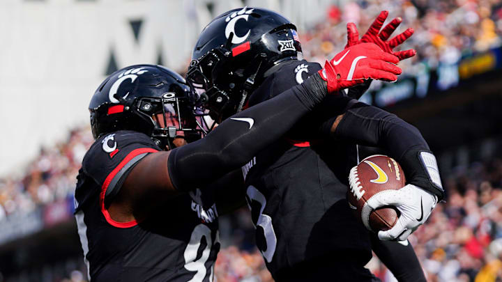 Cincinnati Bearcats defensive back Logan Wilson (13) and defensive end Eric Phillips (97) celebrate after Wilson made an interception in the third quarter of a college football game between the Cincinnati Bearcats and West Virginia Mountaineers, Saturday, Nov. 9, 2024, at Nippert Stadium in Cincinnati. Mountaineers won 31-24.