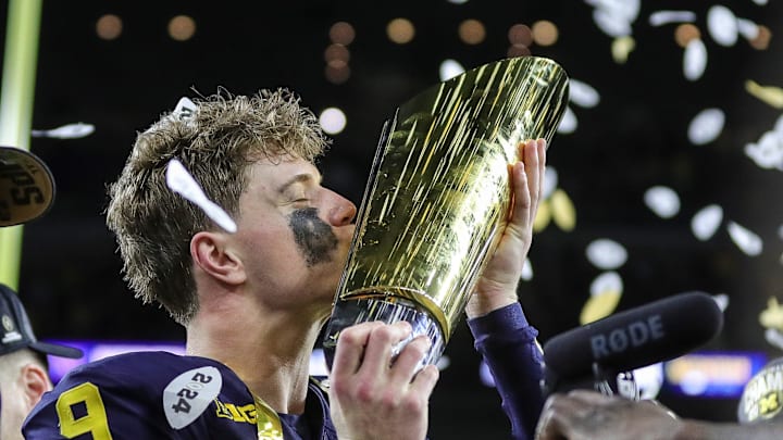 Michigan quarterback J.J. McCarthy (9) kisses the trophy to celebrate 34-13 win over Washington 4.