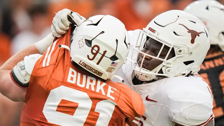 April 20, 2024; Austin, Texas, USA: Texas White team offensive lineman Cameron Williams (56) grabs the uniform of Texas Orange team edge Ethan Burke (91) in the second quarter of the Longhorns' spring Orange and White game at Darrell K Royal Texas Memorial Stadium. Mandatory Credit: Sara Diggins-USA Today Sports via American Statesman