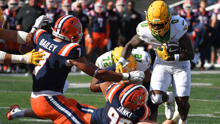 Oct 24, 2026; Champaign, Illinois, USA; Oregon Ducks running back Jordon Davison (0) eludes Illinois Fighting Illini defensive lineman Carter Janki (90) and scores a touchdown during the first half at Gies Memorial Stadium. Mandatory Credit: Ron Johnson-Imagn Images Oct 24, 2026; Champaign, Illinois, USA; Oregon Ducks running back Jordon Davison (0) eludes Illinois Fighting Illini defensive lineman Carter Janki (90) and scores a touchdown during the first half at Gies Memorial Stadium. Mandatory Credit: Ron Johnson-Imagn Images