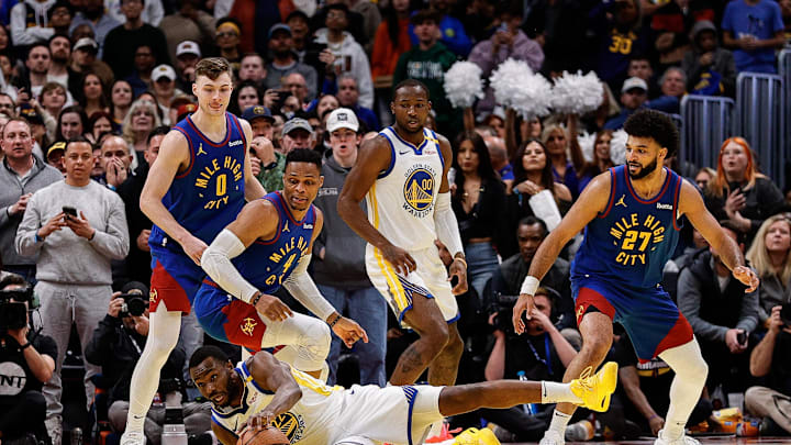 Dec 3, 2024; Denver, Colorado, USA; Golden State Warriors forward Andrew Wiggins (22) reaches for a loose ball ahead of Denver Nuggets guard Russell Westbrook (4) and guard Christian Braun (0) and forward Jonathan Kuminga (00) and guard Jamal Murray (27) in the fourth quarter at Ball Arena. Mandatory Credit: Isaiah J. Downing-Imagn Images