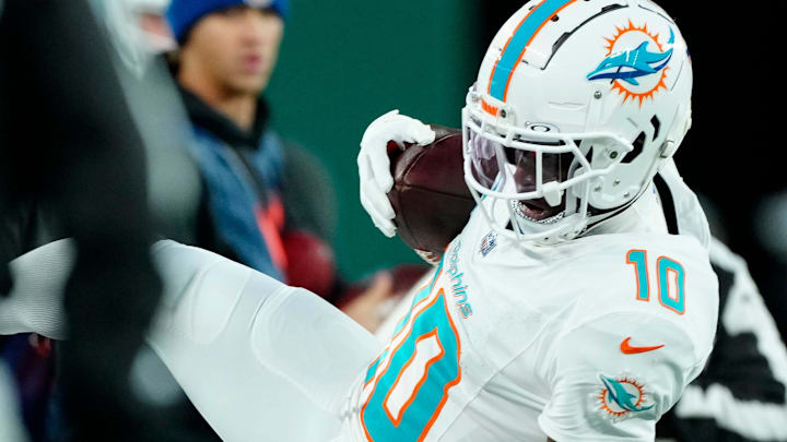 Miami Dolphins wide receiver Tyreek Hill (10) holds onto the ball as New York Jets cornerback Brandin Echols (26) takes him down, Sunday January 5, 2025, in East Rutherford.