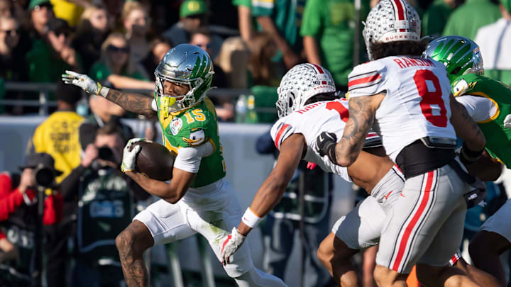 Oregon wide receiver Tez Johnson attempts to avoid a pack of Ohio State defenders as the Oregon Ducks face the Ohio State Buckeyes Wednesday, Jan. 1, 2025, in the quarterfinal of the College Football Playoff at the Rose Bowl in Pasadena, Calif.