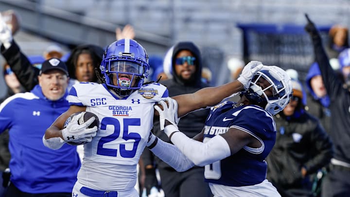 Dec 23, 2023; Boise, ID, USA; Georgia State Panthers running back Freddie Brock (25) gives Utah State Aggies safety Ike Larsen (6) a stiff arm during the first half  at Albertsons Stadium. Mandatory Credit: Brian Losness-Imagn Images
