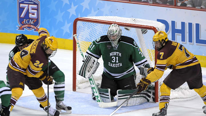 Apr 10, 2014; Philadelphia, PA, USA; Minnesota Gophers forward Hudson Fasching (24) and forward Kyle Rau (7) reach for loose puck in front of North Dakota Sioux goaltender Zane Gothberg (31) during the second period in the semifinals of the Frozen Four college ice hockey tournament at Wells Fargo Center. Apr 10, 2014; Philadelphia, PA, USA; Minnesota Gophers forward Hudson Fasching (24) and forward Kyle Rau (7) reach for loose puck in front of North Dakota Sioux goaltender Zane Gothberg (31) during the second period in the semifinals of the Frozen Four college ice hockey tournament at Wells Fargo Center.
