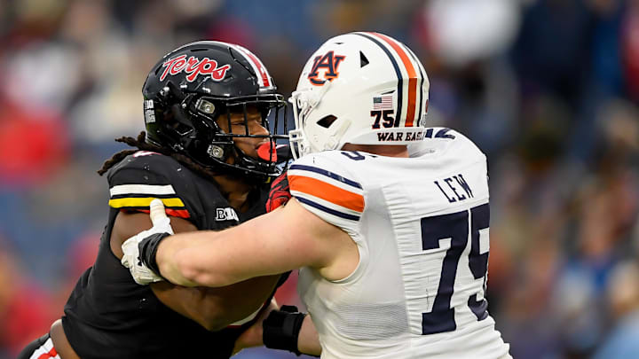 Dec 30, 2023; Nashville, TN, USA;  Maryland Terrapins defensive lineman Christian Teague (91) rushes as Auburn Tigers offensive lineman Connor Lew (75) defends during the second half at Nissan Stadium. Mandatory Credit: Steve Roberts-Imagn Images