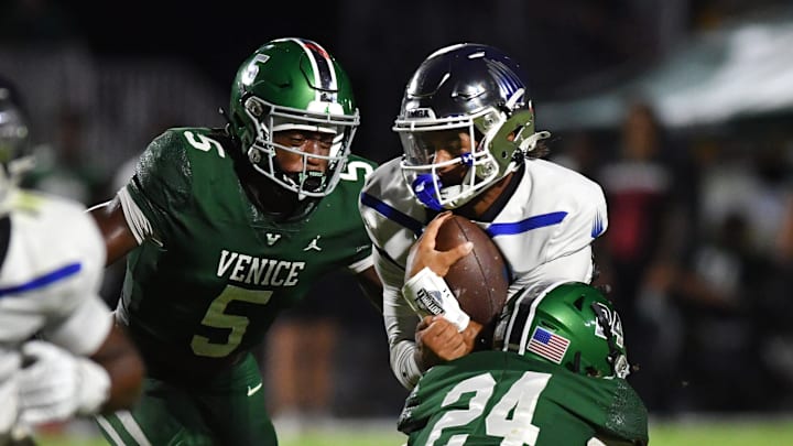 IMG Academy quarterback Ty Hawkins (#2) is met by Venice defenders Asharri Charles (#5) and Tanner Ruh (#24) on a quarterback keeper. The Venice High School Indians hosted the IMG Academy Ascenders National team on Friday, Oct. 4, 2024. IMG Academy quarterback Ty Hawkins (#2) is met by Venice defenders Asharri Charles (#5) and Tanner Ruh (#24) on a quarterback keeper. The Venice High School Indians hosted the IMG Academy Ascenders National team on Friday, Oct. 4, 2024.