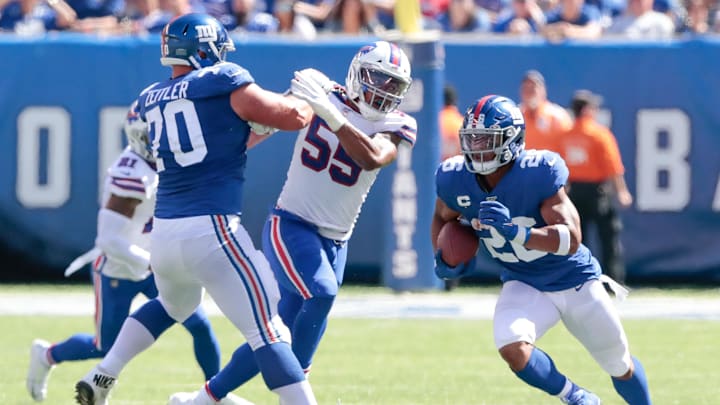 Sep 15, 2019; East Rutherford, NJ, USA; New York Giants running back Saquon Barkley (26) carries the ball as Buffalo Bills defensive end Jerry Hughes (55) is blocked by offensive guard Kevin Zeitler (70) during the first half at MetLife Stadium. Mandatory Credit: Vincent Carchietta-Imagn Images