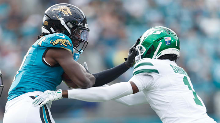Dec 15, 2024; Jacksonville, Florida, USA; Jacksonville Jaguars wide receiver Brian Thomas Jr. (7) stiff-arms New York Jets cornerback Sauce Gardner (1) during the first quarter at EverBank Stadium. Mandatory Credit: Morgan Tencza-Imagn Images