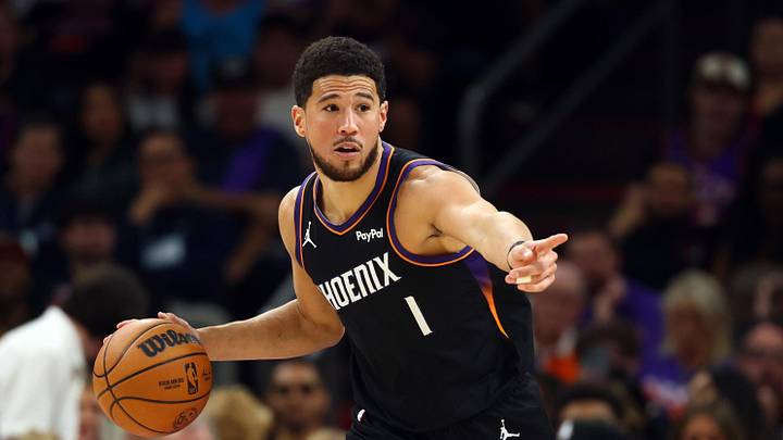 Apr 17, 2026; Phoenix, Arizona, USA; Phoenix Suns guard Devin Booker (1) against the Golden State Warriors during the first half in the play-in rounds of the 2026 NBA Playoffs at Mortgage Matchup Center. Mandatory Credit: Mark J. Rebilas-Imagn Images