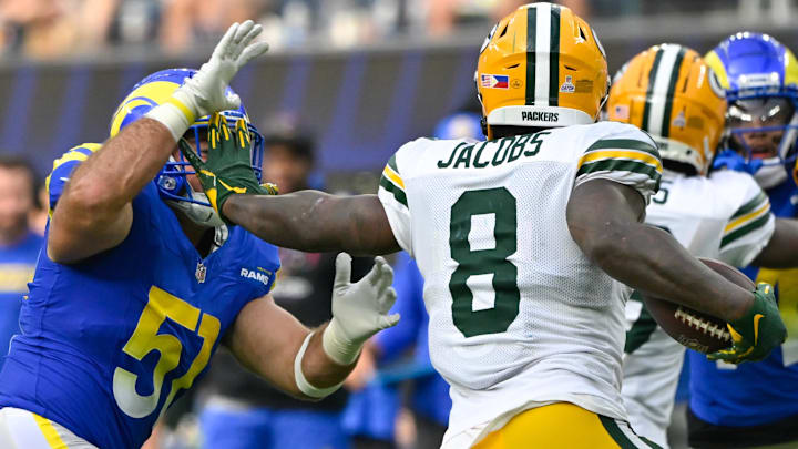 Oct 6, 2024; Inglewood, California, USA; Green Bay Packers running back Josh Jacobs (8) stiff arms Los Angeles Rams linebacker Troy Reeder (51) during the third quarter at SoFi Stadium. Mandatory Credit: Robert Hanashiro-Imagn Images