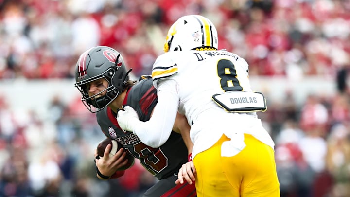 Nov 22, 2025; Norman, Oklahoma, USA;  Oklahoma Sooners quarterback John Mateer (10) is tackled by Missouri Tigers defensive end Damon Wilson II (8) during the first half at Gaylord Family-Oklahoma Memorial Stadium. Mandatory Credit: Kevin Jairaj-Imagn Images