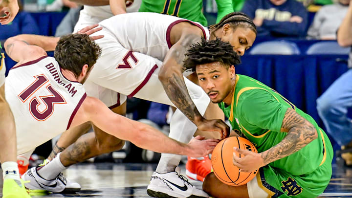Feb 8, 2025; South Bend, Indiana, USA; Virginia Tech Hokies forward Ben Burnham (13) Notre Dame Fighting Irish guard Julian Roper II (1) and Virginia Tech Hokies forward Tobi Lawal (1) reach for a loose ball in the first half at the Purcell Pavilion. Mandatory Credit: Matt Cashore-Imagn Images