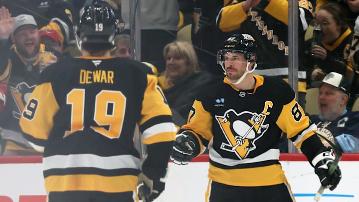 Apr 17, 2025; Pittsburgh, Pennsylvania, USA;  Pittsburgh Penguins center Sidney Crosby (87) reacts with center Connor Dewar (19) after Crosby scored a goal against the Washington Capitals during the second period at PPG Paints Arena. Mandatory Credit: Charles LeClaire-Imagn Images