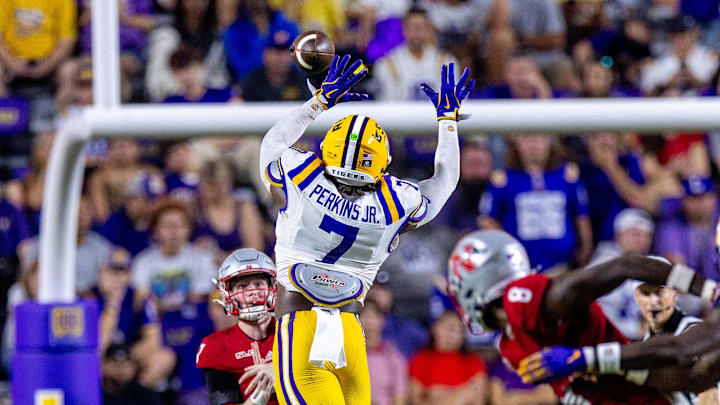 Sep 7, 2024; Baton Rouge, Louisiana, USA; Nicholls State Colonels quarterback Pat McQuaide (7) rolls out of the pocket against LSU Tigers linebacker Harold Perkins Jr. (7) during the second half at Tiger Stadium. Mandatory Credit: Stephen Lew-Imagn Images