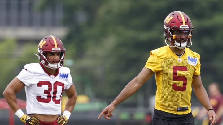 Jun 5, 2024; Ashburn, VA, USA; Washington Commanders quarterback Jayden Daniels (5) gestures as Commanders running back Austin Ekeler (30) looks on during OTA workouts at Commanders Park. Mandatory Credit: Geoff Burke-USA TODAY Sports