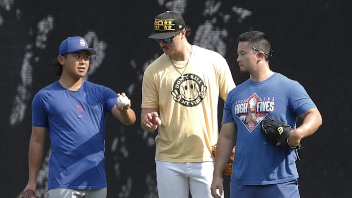 Chicago Cubs pitcher Shota Imanaga (left) and Pittsburgh Pirates pitcher Paul Skenes (middle) discuss pitching grips as Edwin Stanberry (right) interprets before the Pirates host the Cubs at PNC Park on Aug 27.