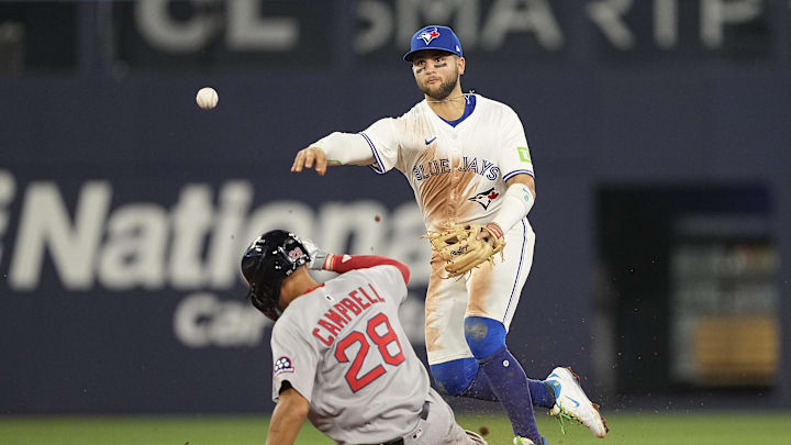 Apr 29, 2025; Toronto, Ontario, CAN; Toronto Blue Jays shortstop Bo Bichette (11) turns a double play against Boston Red Sox second baseman Kristian Campbell (28) and Boston Red Sox first baseman Triston Casas (not pictured) at first base to end the fifth inning at Rogers Centre. Mandatory Credit: John E. Sokolowski-Imagn Images