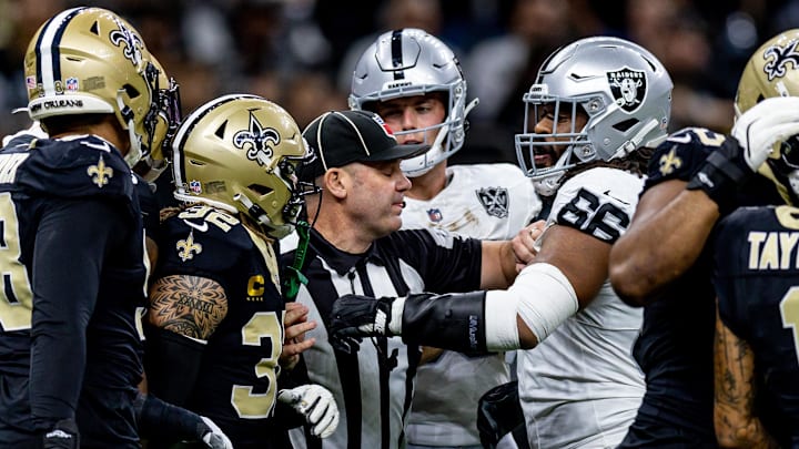 Dec 29, 2024; New Orleans, Louisiana, USA;  Las Vegas Raiders guard Dylan Parham (66) has to held back after throwing a punch at New Orleans Saints cornerback Alontae Taylor (1) during the first half at Caesars Superdome. Mandatory Credit: Stephen Lew-Imagn Images