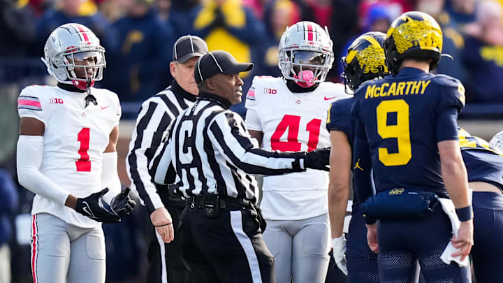Nov 25, 2023; Ann Arbor, Michigan, USA; An official separates Ohio State Buckeyes cornerback Davison Igbinosun (1) and safety Josh Proctor (41) from Michigan Wolverines wide receiver Roman Wilson (1) and quarterback J.J. McCarthy (9) during the NCAA football game at Michigan Stadium. Ohio State lost 30-24.
