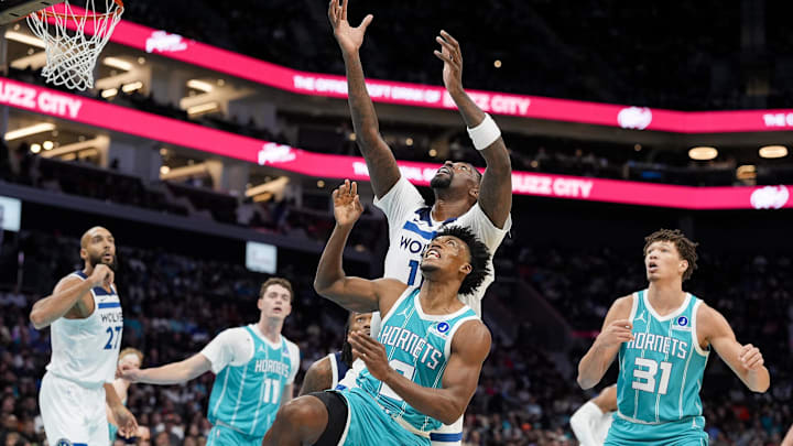 Nov 1, 2025; Charlotte, North Carolina, USA; Minnesota Timberwolves center Naz Reid (11) and Charlotte Hornets guard Collin Sexton (8) leap for the rebound during the second quarter at Spectrum Center. Mandatory Credit: Jim Dedmon-Imagn Images
