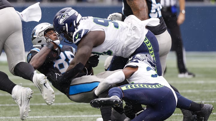Sep 24, 2023; Seattle, Washington, USA; Seattle Seahawks defensive tackle Jarran Reed (90) assists cornerback Artie Burns (23) on a tackle of Carolina Panthers wide receiver Terrace Marshall Jr. (88) during the fourth quarter at Lumen Field. Mandatory Credit: Joe Nicholson-Imagn Images