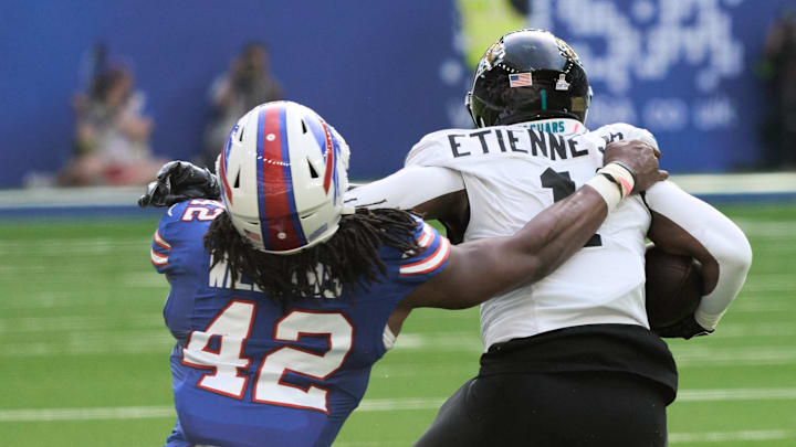 Jacksonville Jaguars running back Travis Etienne Jr. (1) slips past Buffalo Bills linebacker Dorian Williams (42) during the first half of an NFL International Series game at Tottenham Hotspur Stadium