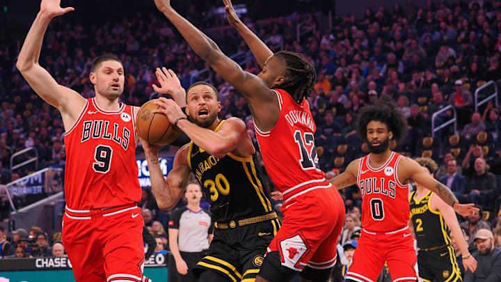 Mar 7, 2024; San Francisco, California, USA; Golden State Warriors guard Stephen Curry (30) drives between Chicago Bulls center Nikola Vucevic (9) and guard Ayo Dosunmu (12) during the first quarter at Chase Center. Mandatory Credit: Kelley L Cox-Imagn Images