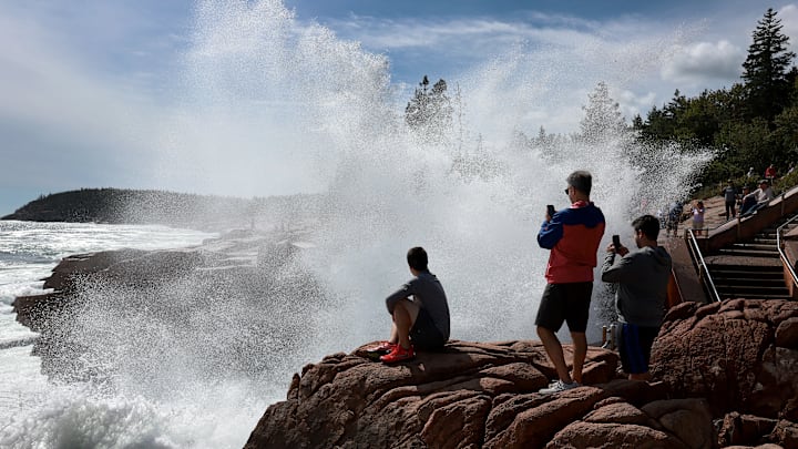 Visitors to Acadia National Park enjoy the spray from Thunder Hole