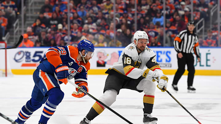 Tomas Hertl and Leon Draisaitl battle for the puck on Sunday night