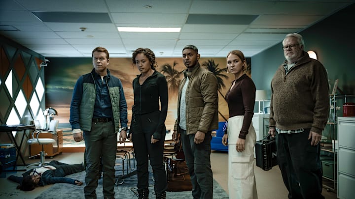 “South of Nowhere” – L-R: Todd Lasance as AFP Liaison Officer Sergeant Jim 'JD' Dempsey, Olivia Swann as NCIS Special Agent Captain Michelle Mackey, Sean Sagar as NCIS Special Agent DeShawn Jackson, Tuuli Narkle as AFP Liaison Officer Constable Evie Cooper and William McInnes as Forensic Pathologist Dr. Roy Penrose in NCIS: Sydney episode 9, season 3 streaming on Paramount+, 2025. Photo Credit: Daniel Asher Smith/Paramount+ © TM & © 2025 CBS Studios Inc. NCIS: Sydney and related marks and