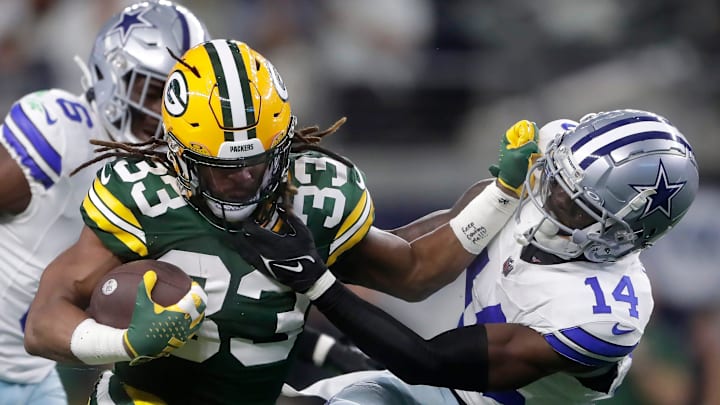 Green Bay Packers running back Aaron Jones (33) rushes against Dallas Cowboys safety Markquese Bell (14) during the first quarter of their wild card playoff game Sunday, January 14, 2024 at AT&T Stadium in Arlington, Texas.