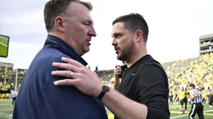 Oct 26, 2024; Eugene, Oregon, USA; Oregon Ducks head coach Dan Lanning and Illinois Fighting Illini head coach Bret Bielema meet after a game at Autzen Stadium. Mandatory Credit: Troy Wayrynen-Imagn Images