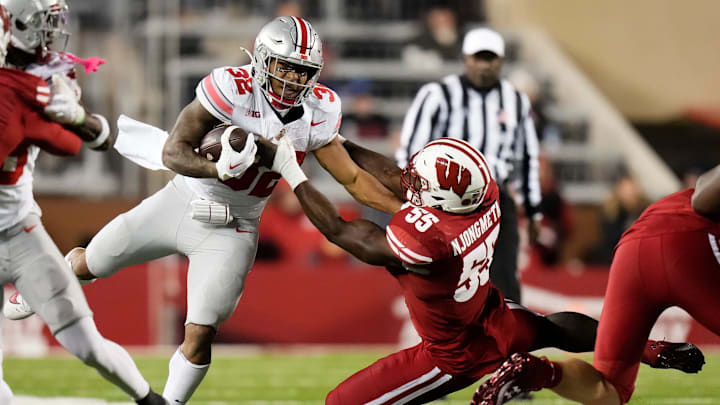 Oct 28, 2023; Madison, Wisconsin, USA; Wisconsin Badgers linebacker Maema Njongmeta (55) attempts to tackle Ohio State Buckeyes running back TreVeyon Henderson (32) during the second half of the NCAA football game at Camp Randall Stadium.