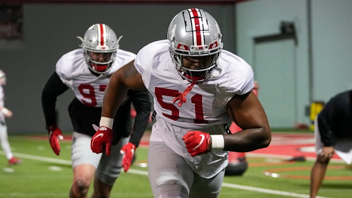 Ohio State Buckeyes defensive tackle Mike Hall (51) and defensive lineman Noah Potter (97) run