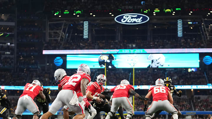 Dec 29, 2023; Arlington, Texas, USA; Ohio State Buckeyes quarterback Lincoln Kienholz (12) hands off to running back TreVeyon Henderson (32) during the second quarter of the Goodyear Cotton Bowl Classic against the Missouri Tigers at AT&T Stadium.