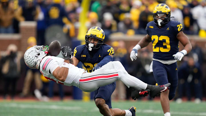 Nov 25, 2023; Ann Arbor, Michigan, USA; Michigan Wolverines defensive back Quinten Johnson (28) hits Ohio State Buckeyes wide receiver Emeka Egbuka (2) forcing an incomplete pass during the second half of the NCAA football game at Michigan Stadium. Ohio State lost 30-24.