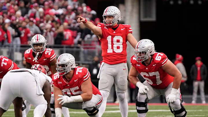 Ohio State Buckeyes quarterback Will Howard (18) motions behind offensive lineman Carson Hinzman (75) and offensive lineman Austin Siereveld (67) during the NCAA football game at Ohio Stadium in Columbus on Monday, Nov. 25, 2024. Ohio State won 38-15.