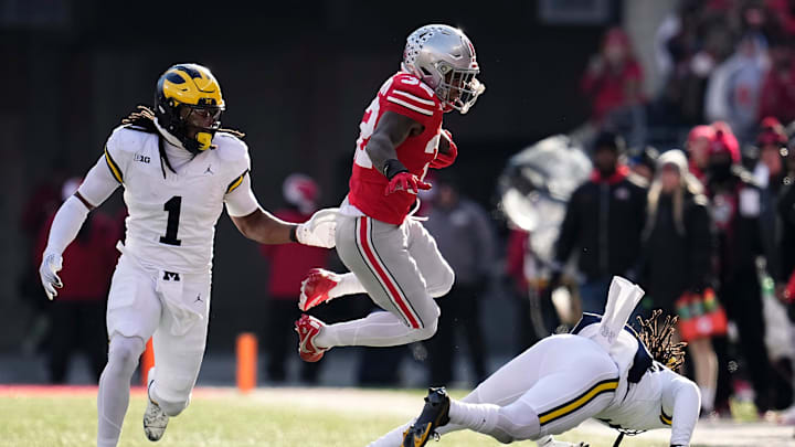 Ohio State Buckeyes running back TreVeyon Henderson (32) leaps in front of Michigan Wolverines linebacker Jaishawn Barham (1) during the second half of the NCAA football game at Ohio Stadium in Columbus on Saturday, Nov. 30, 2024. Michigan won 13-10.
