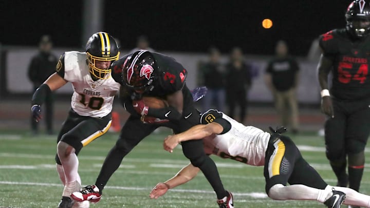 Rio Mesa's J'lin Wingo is stopped by Ventura's Mylan Walker and Tristan Phillips