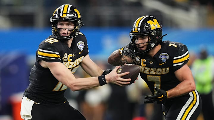 Dec 29, 2023; Arlington, Texas, USA; Missouri Tigers quarterback Brady Cook (12) hands off to Cody Schrader (7).
