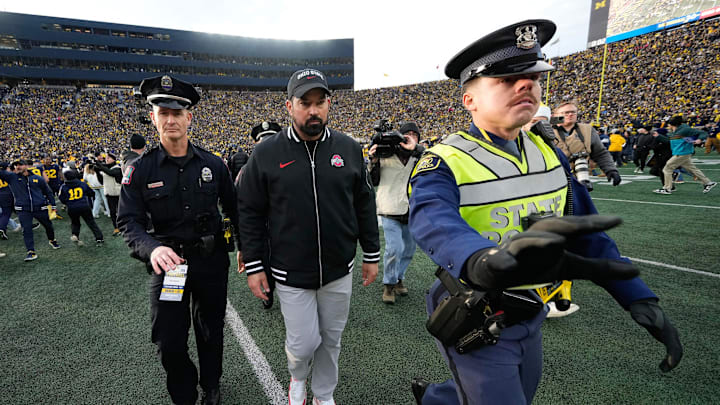 Nov 25, 2023; Ann Arbor, Michigan, USA; As fans rush the field, Ohio State Buckeyes head coach Ryan