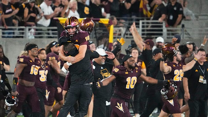 Oct 11, 2024; Tempe, Arizona, USA; Arizona State Sun Devils quarterback Sam Leavitt (10) jumps into the arms of head coach Kenny Dillingham after the the Sun Devils upset the (16) Utah Utes 27-19 at Mountain America Stadium. Mandatory Credit: Rob Schumacher-Arizona Republic