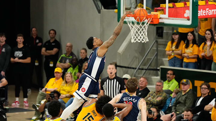 Feb 17, 2025; Waco, Texas, USA;  Arizona Wildcats guard Caleb Love (1) dunks the ball over Baylor Bears forward Norchad Omier (15) during the second half at Paul and Alejandra Foster Pavilion. Mandatory Credit: Chris Jones-Imagn Images