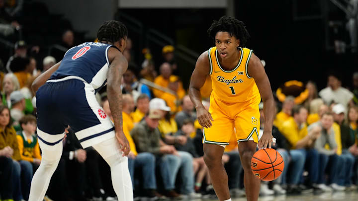 Feb 17, 2025; Waco, Texas, USA;  Baylor Bears guard Robert Wright III (1) controls the ballas Arizona Wildcats guard Jaden Bradley (0) defends during the first half at Paul and Alejandra Foster Pavilion. Mandatory Credit: Chris Jones-Imagn Images