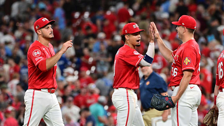 Aug 17, 2024; St. Louis, Missouri, USA;  St. Louis Cardinals third base Nolan Arenado (28) and shortstop Masyn Winn (0) greet St. Louis Cardinals pitcher Ryan Helsley (56, right) after Helsley pitched in relief in the ninth inning against the Los Angeles Dodgers at Busch Stadium. Mandatory Credit: Tim Vizer-Imagn Images