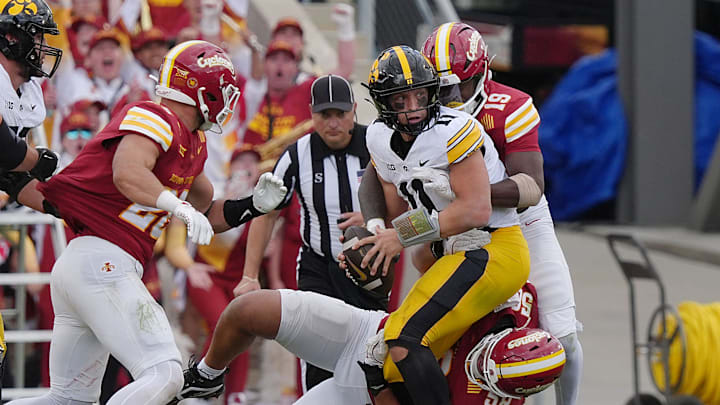 Iowa State defensive line Tamatoa McDDonough (58) and defensive back Ta’Shawn James (19) take down Iowa Hawkeyes quarterback Mark Gronowski (11) during the last second of the fourth quarter quarter in the Cy-Hawk football at Jack Trice Stadium on Sept. 6, 2025, in Ames, Iowa