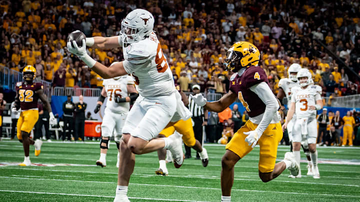 Texas Longhorns tight end Gunnar Helm (85) catches a pass to score a touchdown, evading defense from Arizona State Sun Devils defensive back Myles Rowser (4), during the second overtime period as the Texas Longhorns play the Arizona State Sun Devils in the Peach Bowl College Football Playoff quarterfinal at Mercedes-Benz Stadium in Atlanta, Georgia, Jan. 1, 2025.