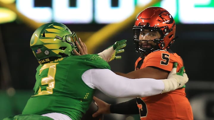 Oregon   s Brandon Dorlus, left, pressures Oregon State quarterback DJ Uiagalelei during the third
